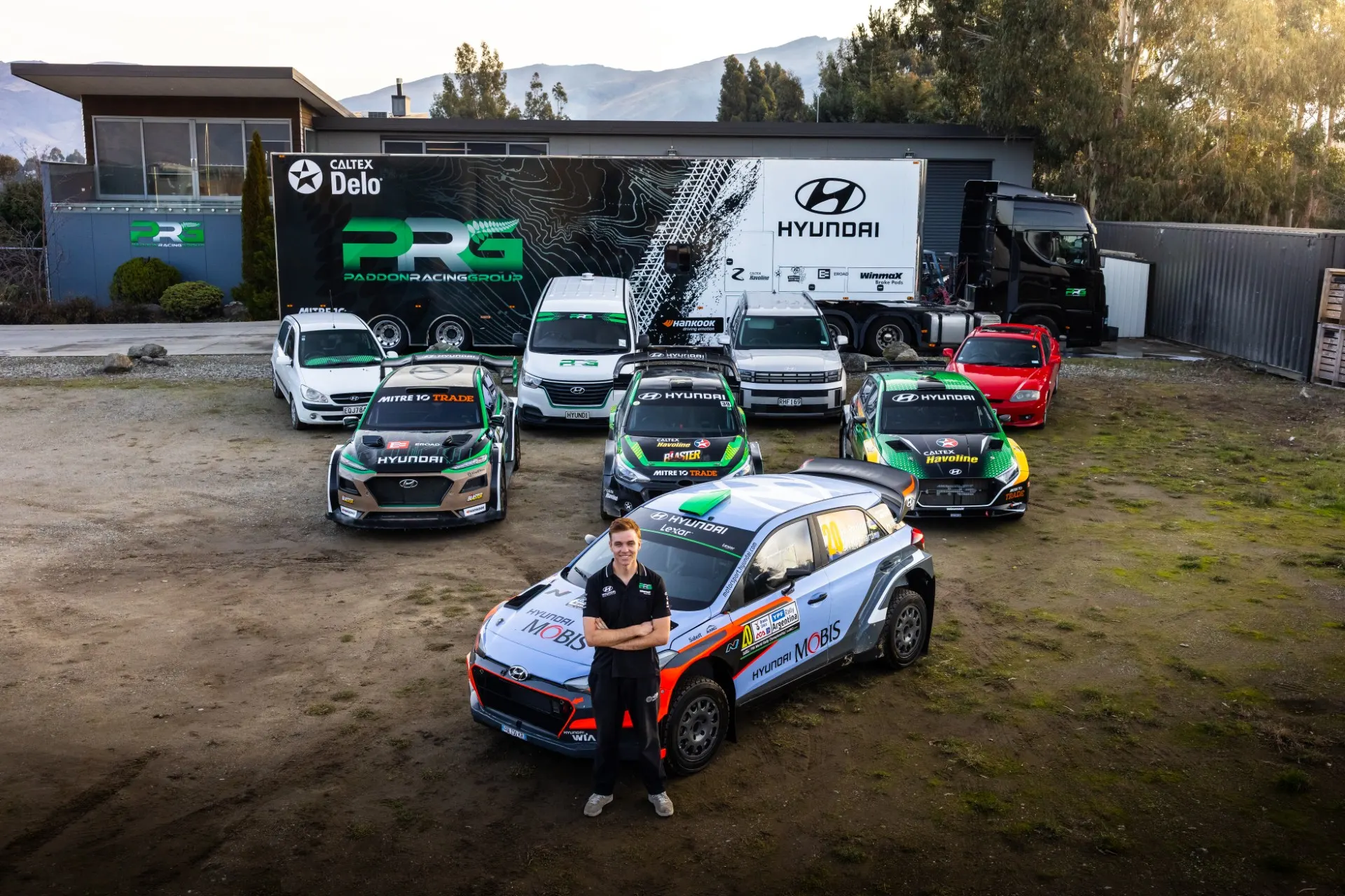 Hayden Paddon beside a Paddon Racing Group rally car